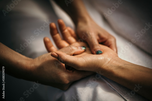 Massage therapist massaging woman's hand photo