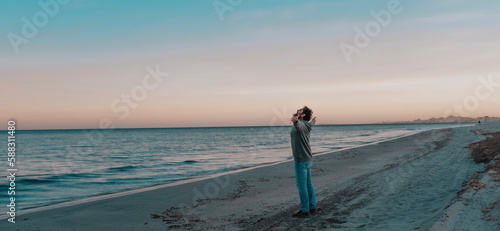 Mature man standing with arms outstretched at beach