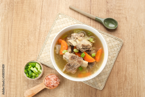 Sop Iga (Beef ribs soup) made from ribs, carrots, leeks.  Served in white bowl. Indonesian food