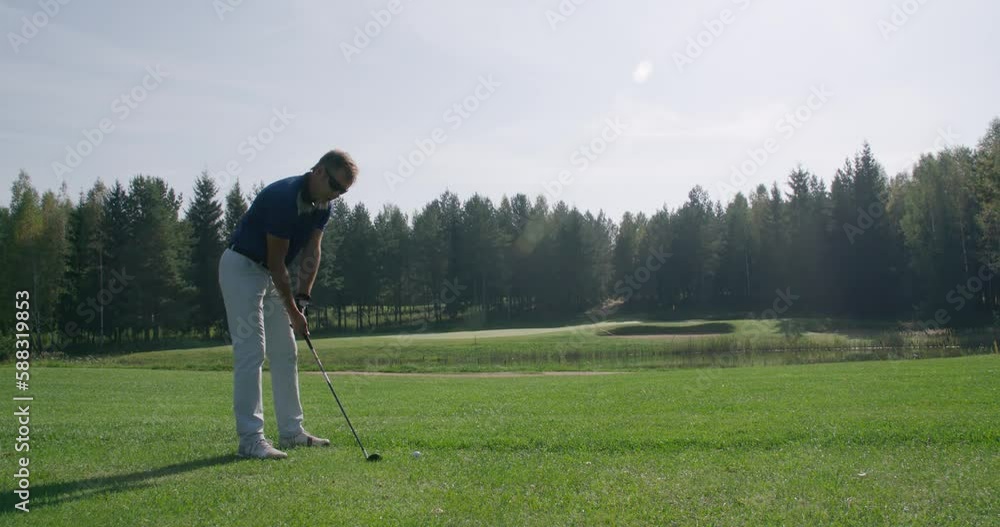 Summer day, adult man playing Golf, misses the ball, view of golf course in forest area, green lawn. Summer day, adult man playing Golf, misses the ball, view of golf course in forest area, green lawn.