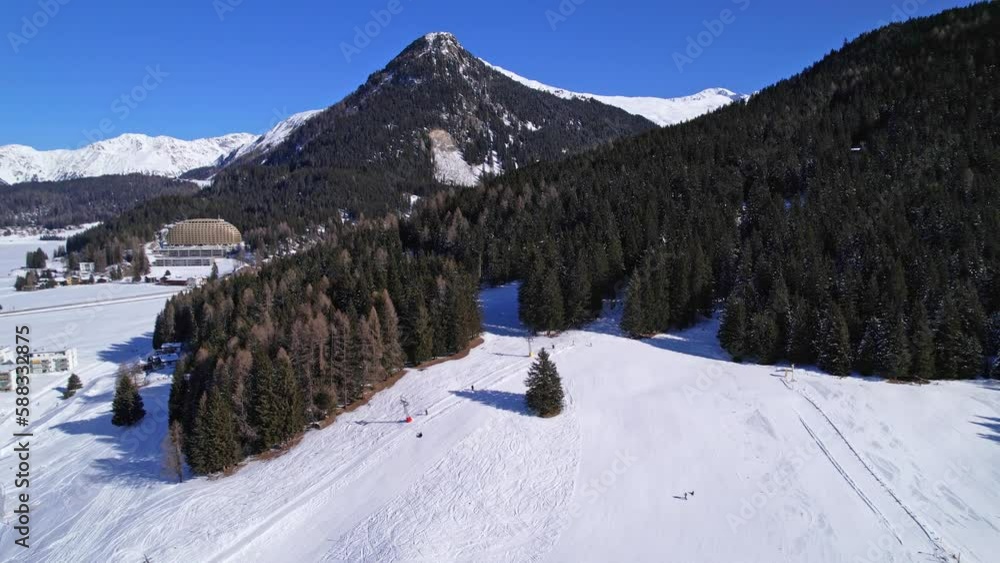 Winter scenery of Alp peaks with evergreen forest covered in snow. Aerial parallax shot. Davos, Switzerland Winter scenery of Alp peaks with evergreen forest covered in snow. Aerial parallax shot. Davos, Switzerland