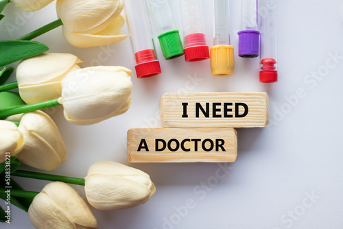TEXT I NEED A DOCTOR and medical test tubes with flowers on a white background