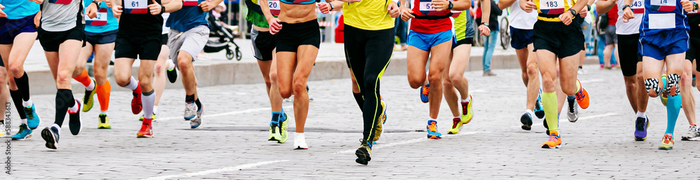 large group male and female runners run marathon city race in paving stones large group male and female runners run marathon city race in paving stones
