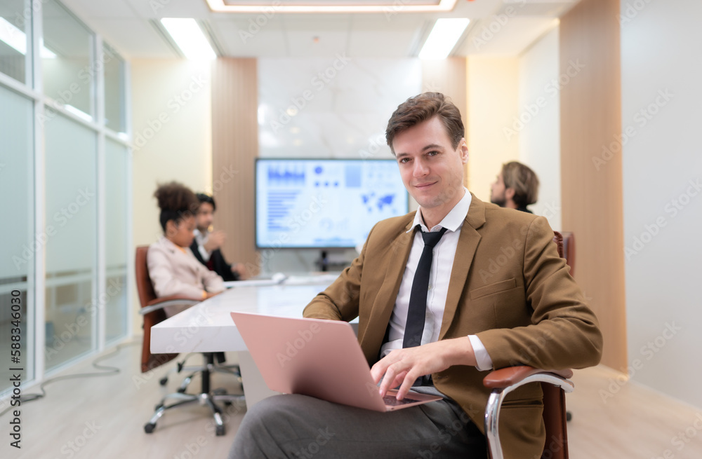 At the meeting room, a young businessman sitting in a secret meeting with many other businessmen the atmosphere is happy At the meeting room, a young businessman sitting in a secret meeting with many other businessmen the atmosphere is happy