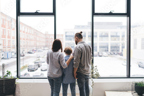 Family admiring parking lot behind window