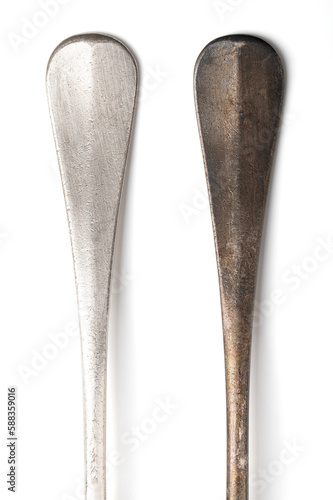 Polished and tarnished sterling silver cutlery handles, old and often used. Hydrogen sulfide and oxygen in the air react with outermost layer of the metal and gives a thin and dark layer of corrosion.