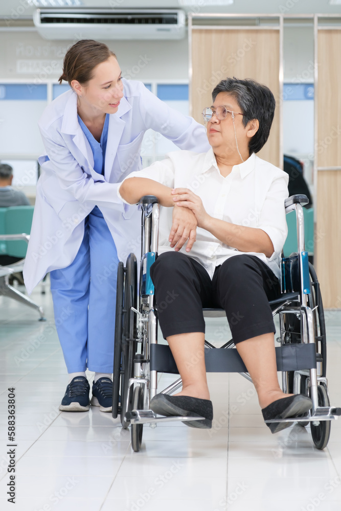 Young female doctor health examining to an old female patient and her family sitting in a wheelchair. Young female doctor health examining to an old female patient and her family sitting in a wheelchair.
