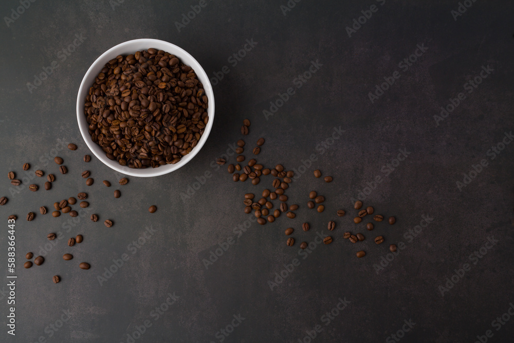 Coffee beans in the white bowl. Top view. on dark stone background. Coffee beans in the white bowl. Top view. on dark stone background.