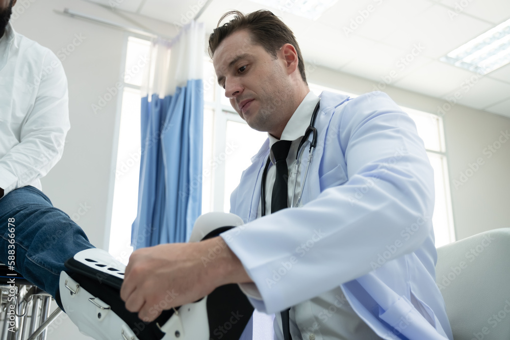 Doctors examine a black patient who has had an accident with a broken leg accompanied by his wife and child. Doctors examine a black patient who has had an accident with a broken leg accompanied by his wife and child.