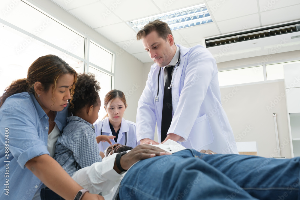 Doctors examine a black patient who has had an accident with a broken leg accompanied by his wife and child. Doctors examine a black patient who has had an accident with a broken leg accompanied by his wife and child.