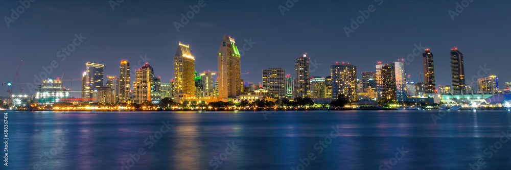 Panorama of San Diego skyline at night with water colorful reflections, view from Coronado island, California