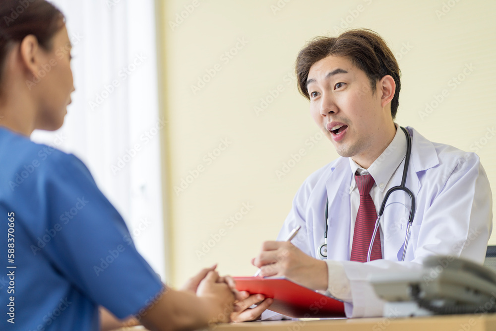 Asian doctor talking to patient with smile to encourage patients at the hospital Asian doctor talking to patient with smile to encourage patients at the hospital