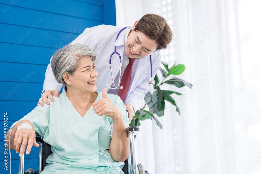 Fototapeta premium A doctor is caring for an elderly female patient at a hospital where she has undergone knee surgery. This made her need to use a wheelchair instead of walking and have a doctor take care of it closely