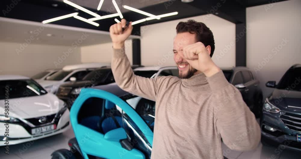 Happy car owner rejoices in buying a new luxury electric car Happy car owner rejoices in buying a new luxury electric car