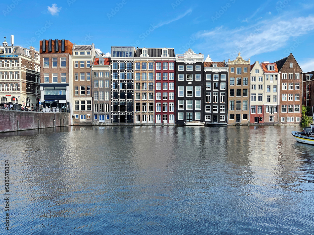 Gracht canal with typical old houses at Damrak in Amsterdam, Netherlands	