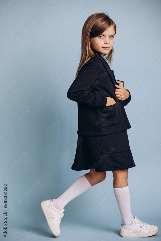 School girl in uniform holding books Stock Photo | Adobe Stock