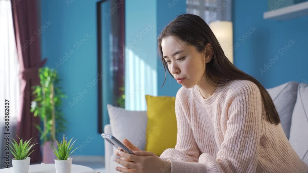 Bored unhappy asian young woman looking at smart phone.
Young asian woman unhappy and depressed at home using her smartphone.
Bored unhappy asian young woman looking at smart phone.
Young asian woman unhappy and depressed at home using her smartphone.