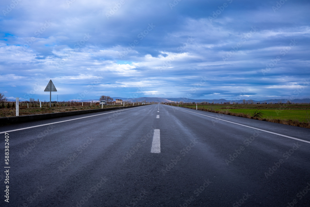 rain-soaked highway and blue sky with clouds rain-soaked highway and blue sky with clouds