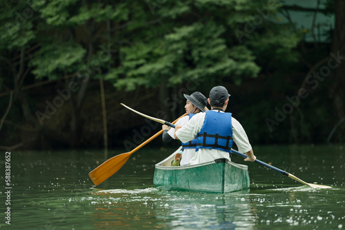 友人と一緒にカヤックで川下りを楽しむ男性