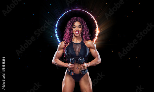 Modern muslim girl bodybuilder before bodybuilding competition. Fitness concept. Sport and health. Egyptian woman athlete posing on a black background.