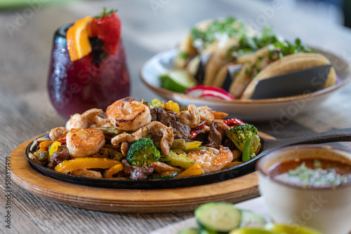 Seafood, beef and chicken fajitas on skillet photo
