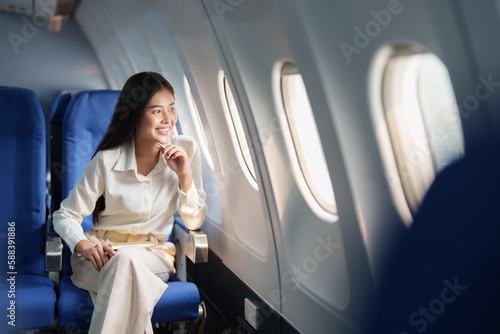 Foto Asian attractive business woman passenger sitting on business class luxury plane