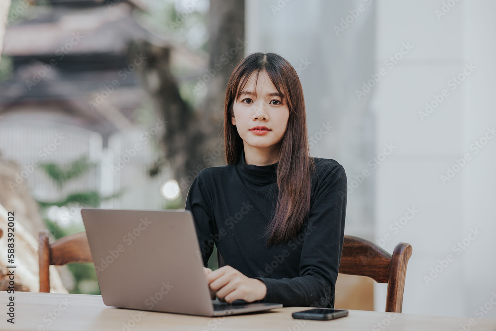Beautiful Asian black shirt woman using laptop in coffee shop. Beautiful Asian black shirt woman using laptop in coffee shop.