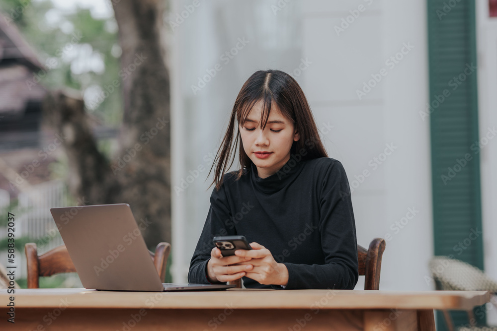 Beautiful Asian black shirt woman using laptop in coffee shop. Beautiful Asian black shirt woman using laptop in coffee shop.