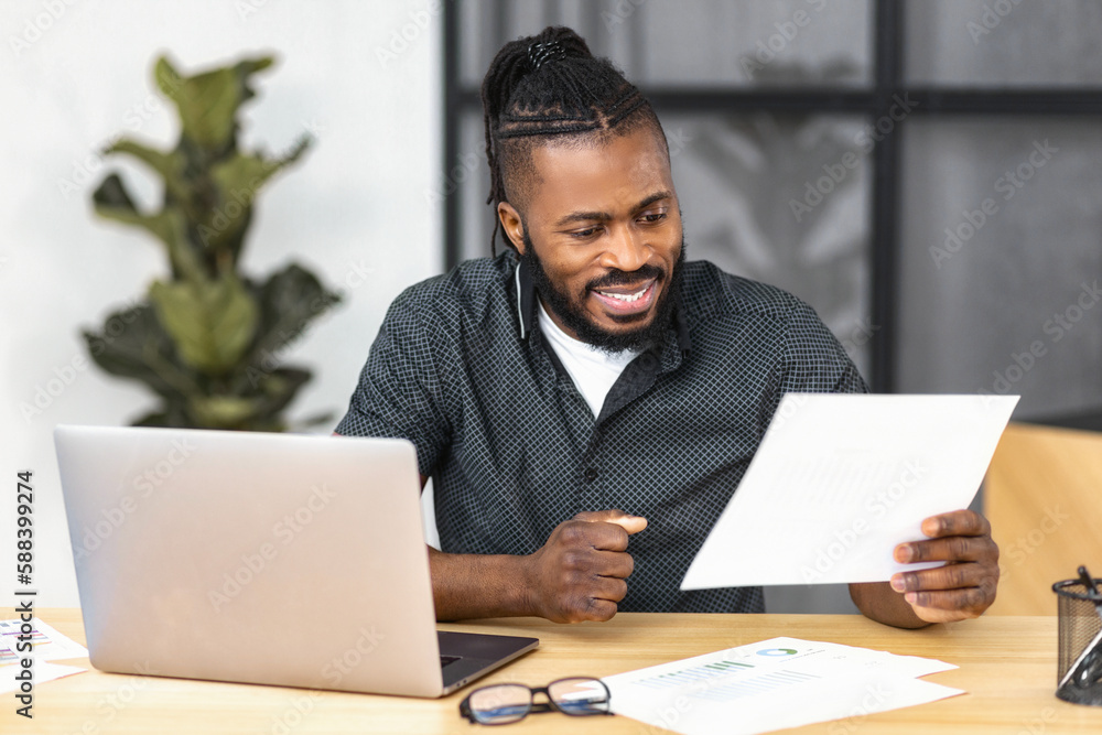 Successful male entrepreneur or CEO, investor or financier looking through a report, working with documents and accounts smiling satisfied with work results andachievements sitting in modern office Successful male entrepreneur or CEO, investor or financier looking through a report, working with documents and accounts smiling satisfied with work results andachievements sitting in modern office