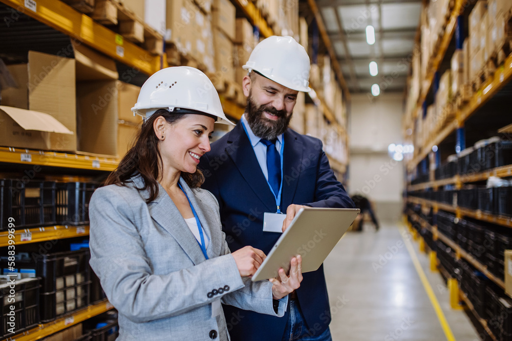 Managers in suit controlling goods in a waehouse. Managers in suit controlling goods in a waehouse.
