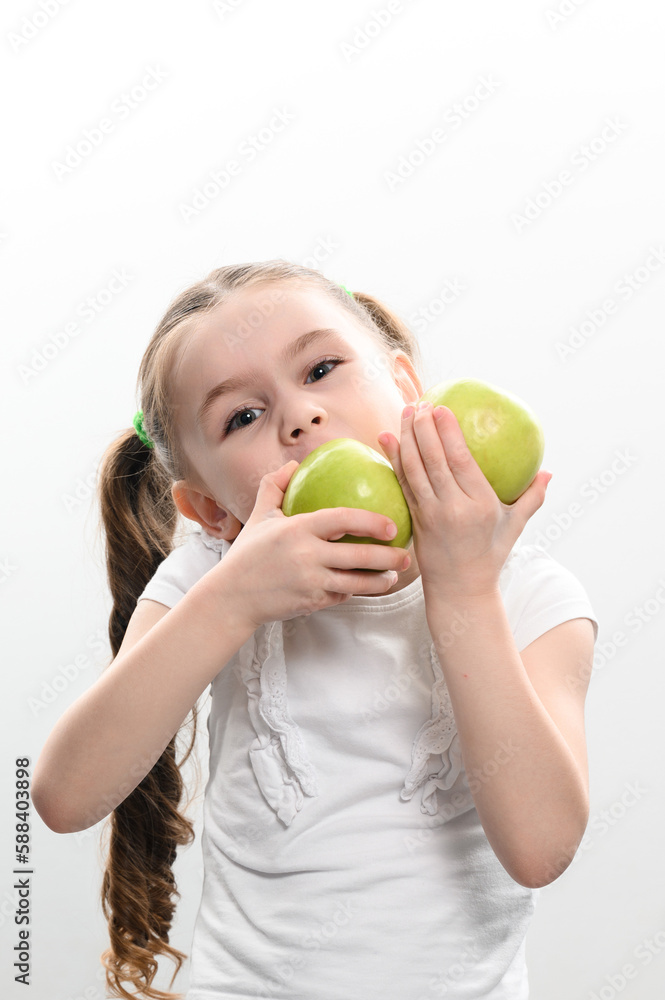 a little girl holds two green apples in her hands on a white background a little girl holds two green apples in her hands on a white background