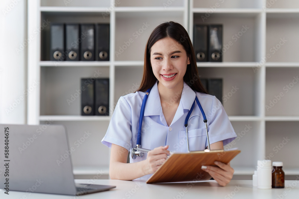 Smiling Happy and Beautiful Doctor working on laptop at clinic, health care, medical, healthy concept Smiling Happy and Beautiful Doctor working on laptop at clinic, health care, medical, healthy concept