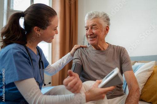 Obraz na plátne Young nurse checking elderly senior in his home.
