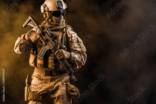 Special Forces Military Unit in Full Tactical Gear posing, on a dusty background and smoke, soldier
