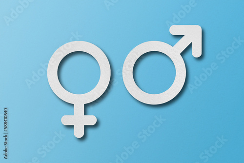 White paper cut into male and female symbol shapes. set on a light blue background