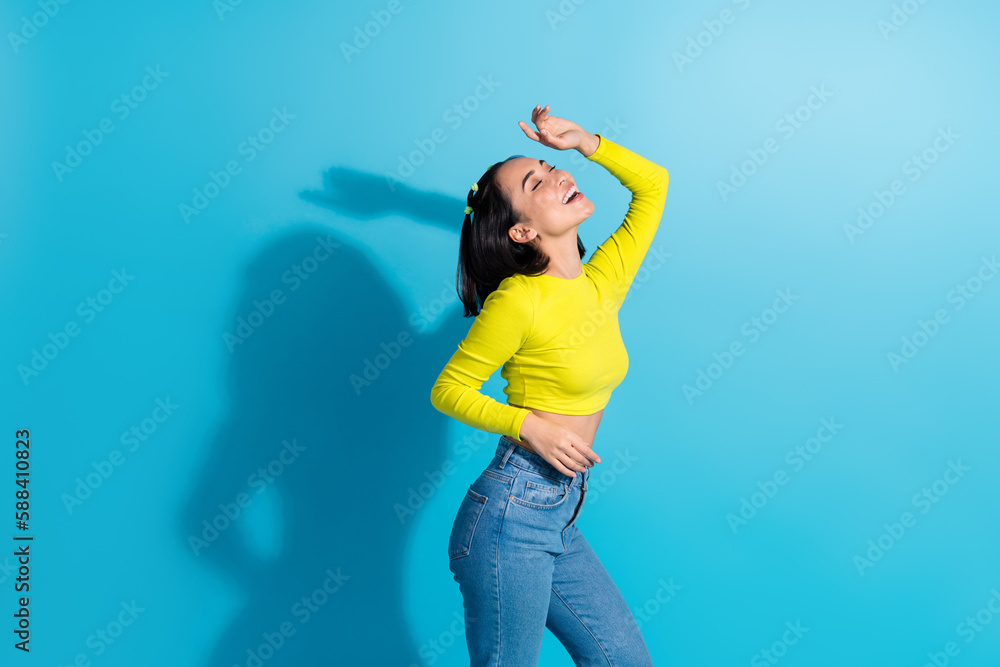 Photo of youngster charming relaxed girl dancing have fun listen pop music wear stylish outfit take rhythm harmony isolated on blue color background Photo of youngster charming relaxed girl dancing have fun listen pop music wear stylish outfit take rhythm harmony isolated on blue color background