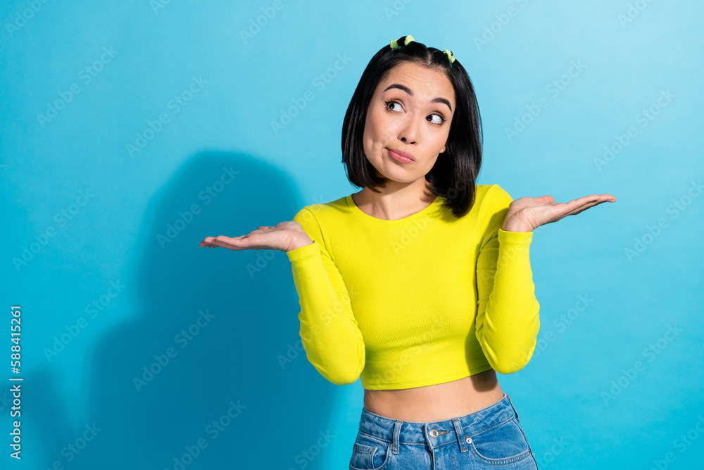 Photo of young slim belly korean girl shrug shoulders dont know answer your question how lose weight wear yellow shirt isolated on blue background Photo of young slim belly korean girl shrug shoulders dont know answer your question how lose weight wear yellow shirt isolated on blue background