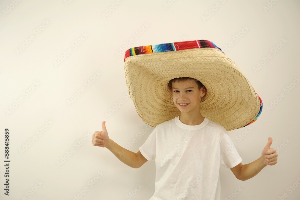 Foto de boy in a huge mexican hat shows thumbs up on both hands class