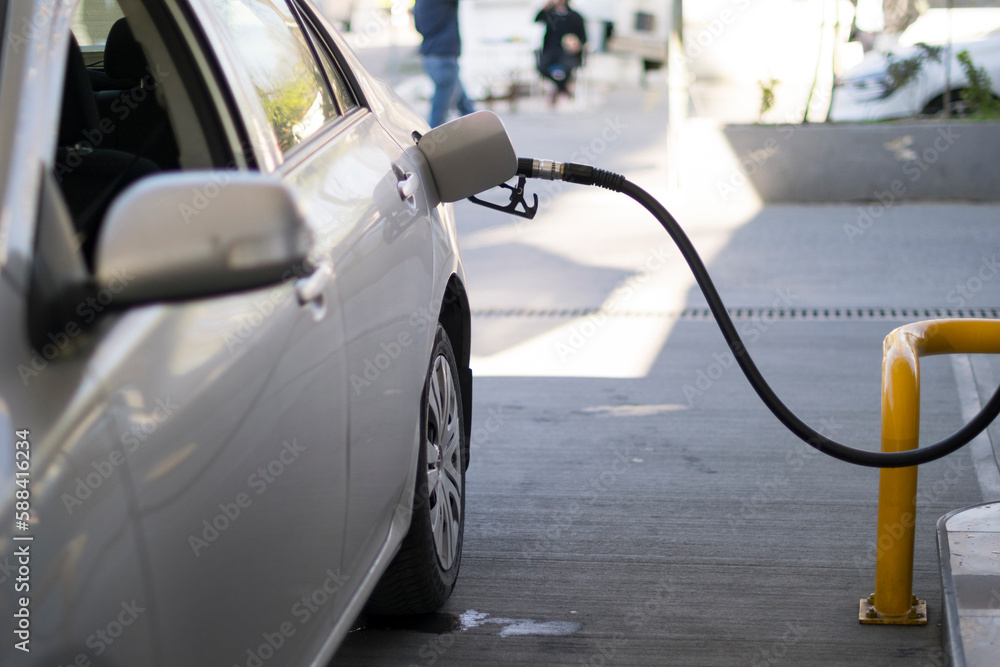 Refuel cars at the fuel pump. The driver hands, refuel and pump the car's gasoline with fuel at the petrol station. Car refueling at a gas station. Refuel cars at the fuel pump. The driver hands, refuel and pump the car's gasoline with fuel at the petrol station. Car refueling at a gas station.