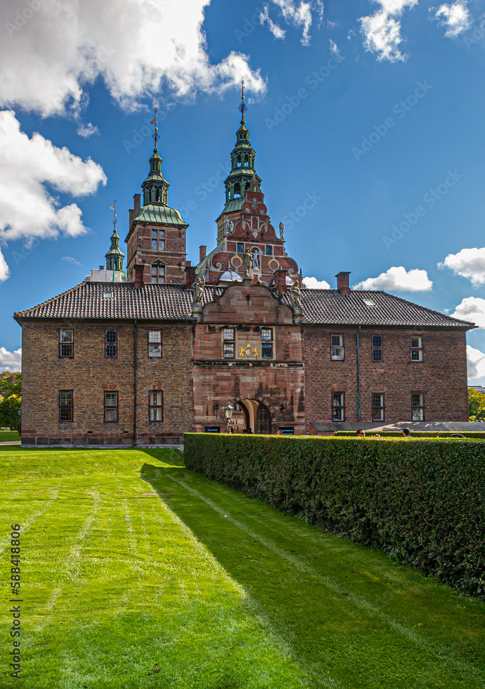 Φωτογραφία Copenhagen, Denmark - September 13, 2010: Cobbled path leads to NW entrance facade of Rosenborg Slot under blue cloudscape