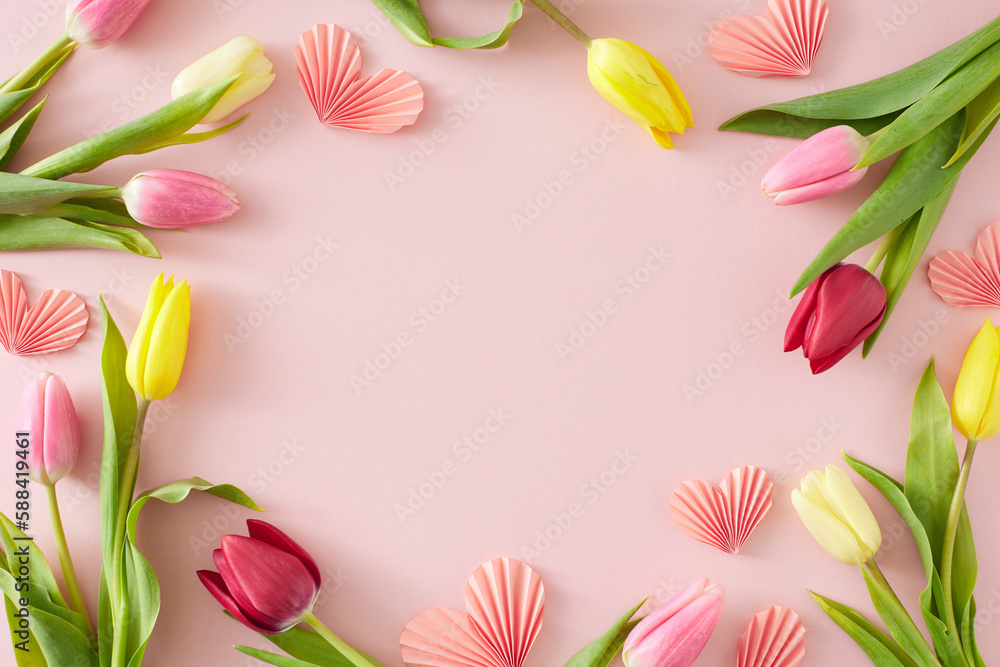 Women's Day concept. Flat lay composition made of pink origami paper hearts colorful tulips flowers on pastel pink background with empty space in the middle
