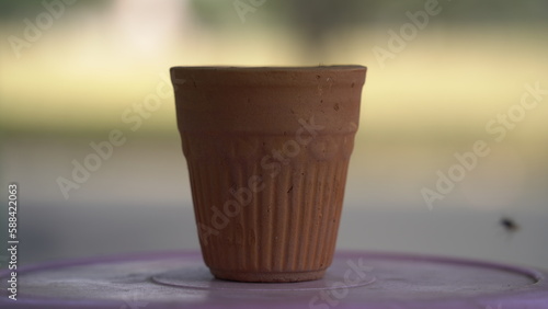 A kulhar or kulhad cup (traditional handle-less clay cup) from India filled with hot Indian tea. photo