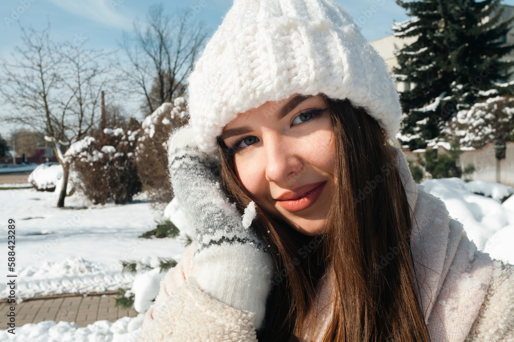 Street photo. A charming young brunette walks along partially snowy streets on a sunny winter day. Street photo. A charming young brunette walks along partially snowy streets on a sunny winter day.