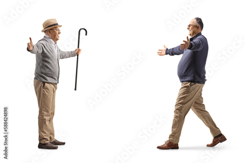 Full length profile shot of a mature man walking towards an elderly gentleman with arms wide open