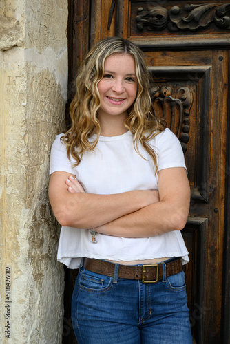 Young pretty teenage girl posing in a historic setting for her high school graduation photos