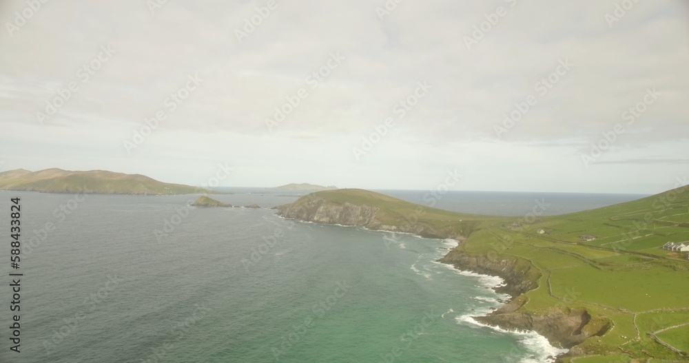 View of landscape by sea against cloudy sky View of landscape by sea against cloudy sky