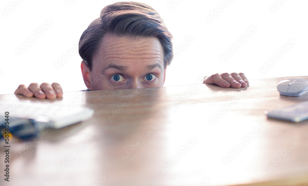 Portrait of buisnessman hiding behind desk Portrait of buisnessman hiding behind desk