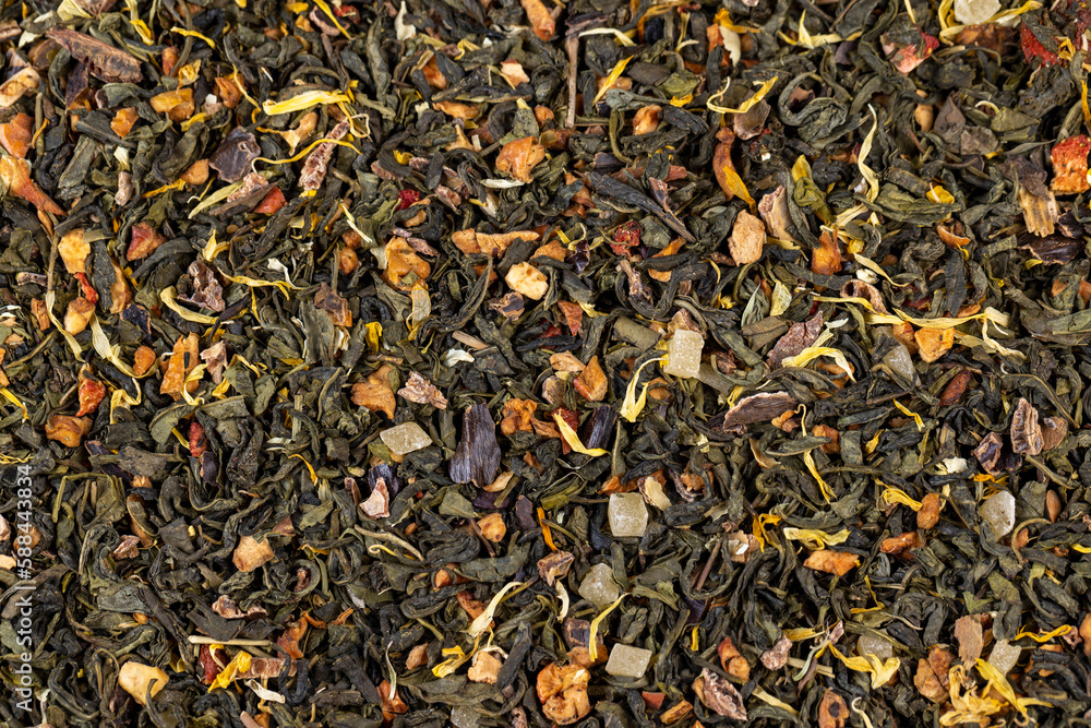 A large amount of dry green tea with pieces of fruit A large amount of dry green tea with pieces of fruit