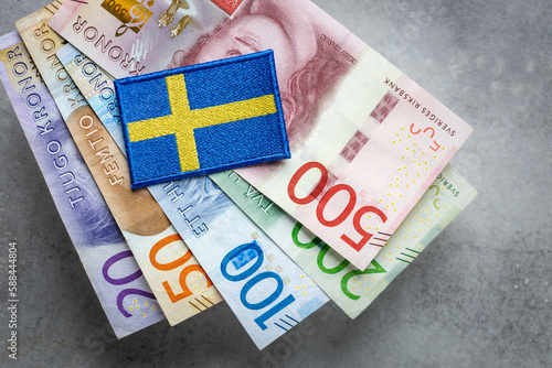 Sweden flag lying on a bundle of swedish kronas, Currency of Sweden, business and financial concept photo