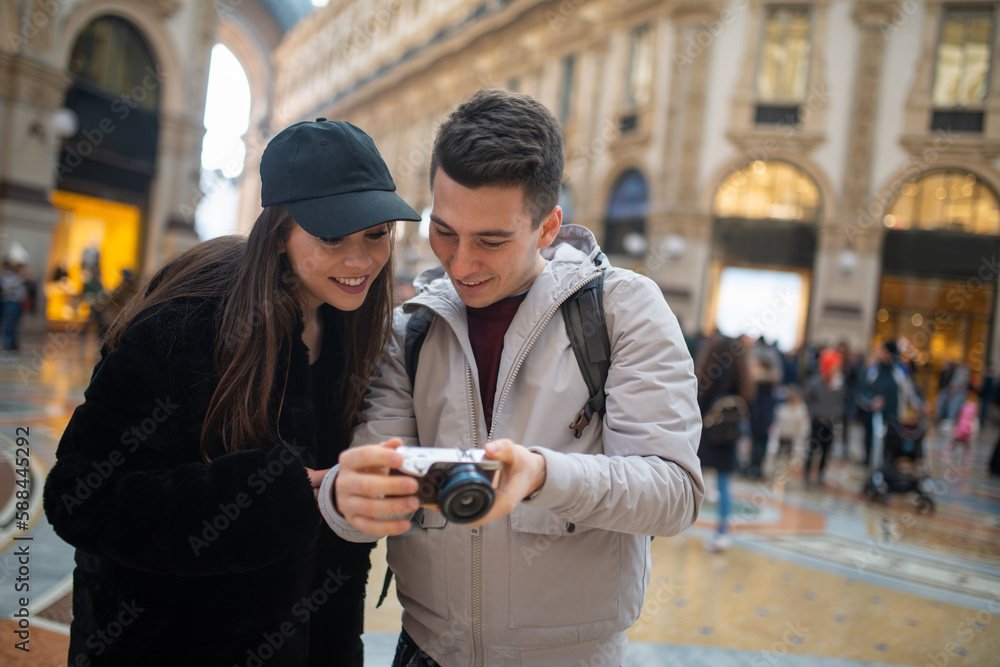Tourists looking at the pictures shot in their trip Tourists looking at the pictures shot in their trip